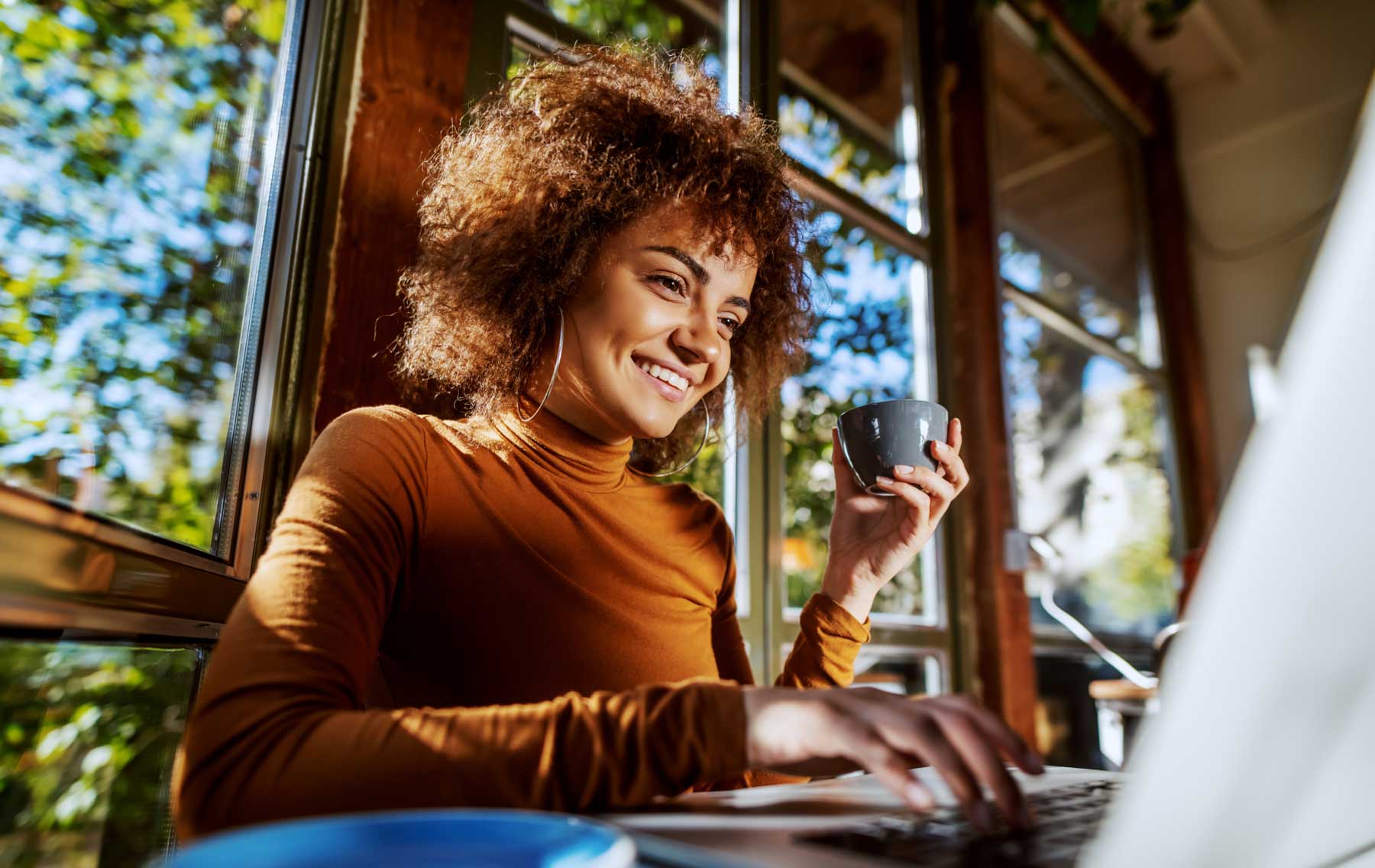 Image d'une femme qui sourit devant son ordinateur portable